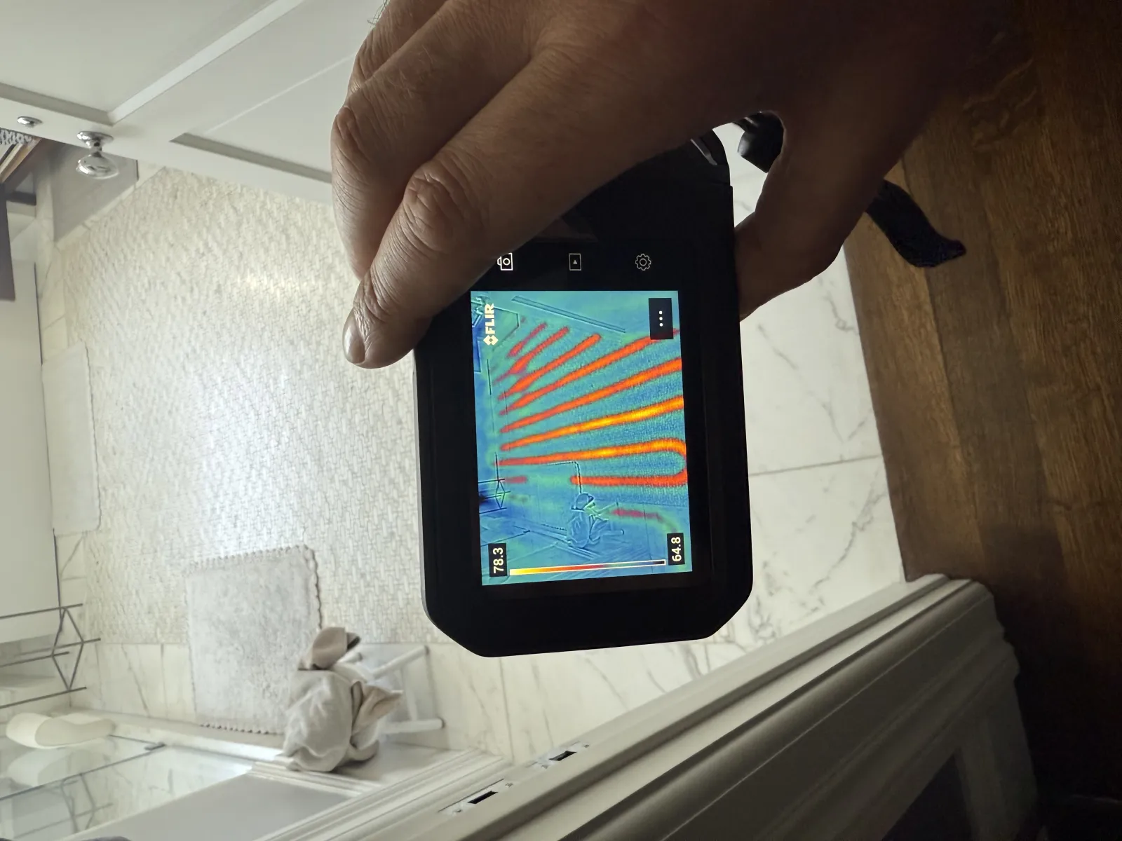 FLIR thermal camera showing radiant floor heating pattern under bathroom tile during Hydroflow diagnostic inspection