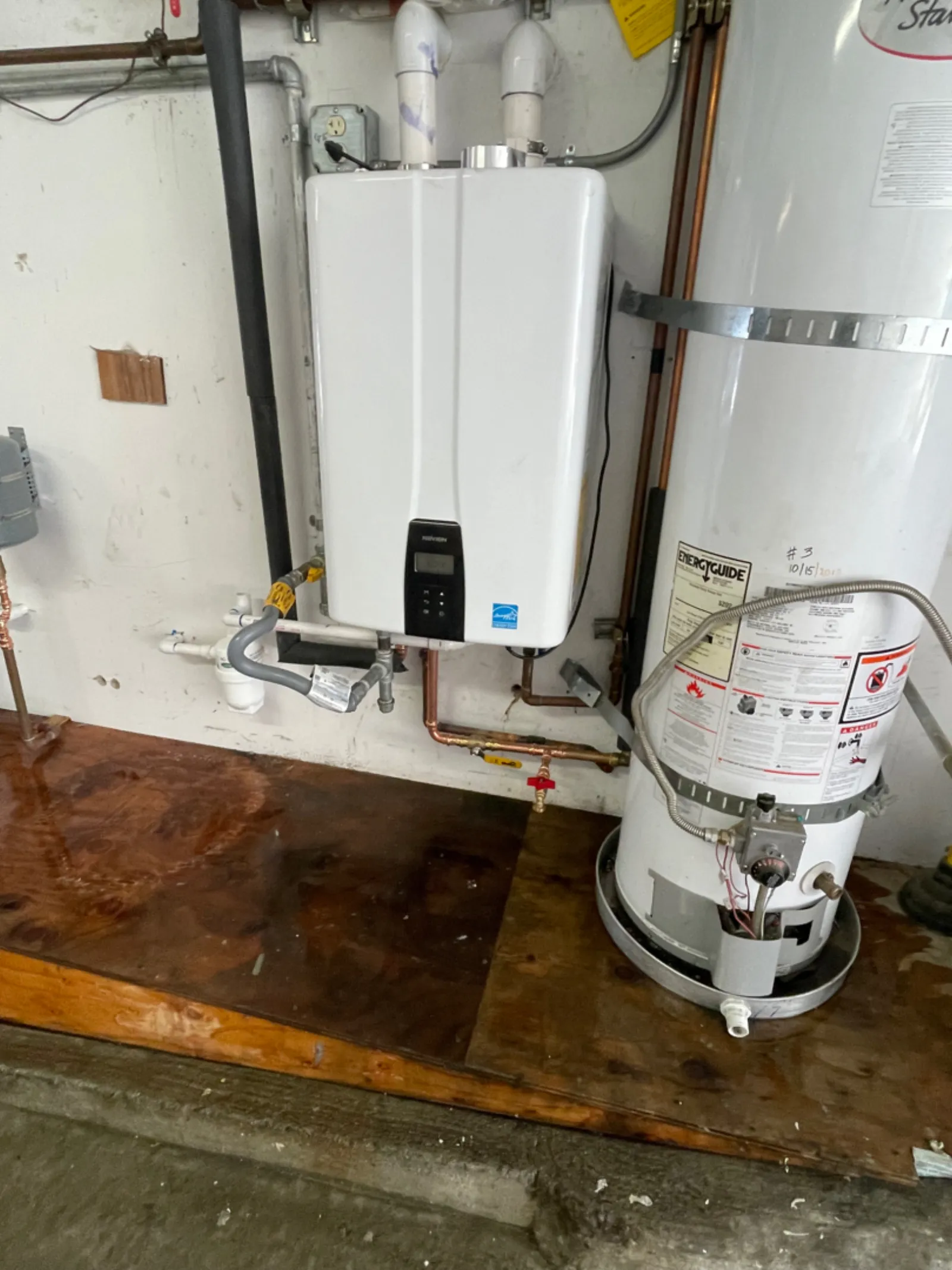 Navien tankless water heater installed next to an old tank water heater in a San Francisco garage by Hydroflow